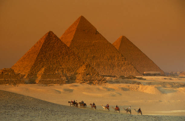 Giza area , Cairo,  Egypt- March 15, 2024Tourists visit the pyramids with camels.