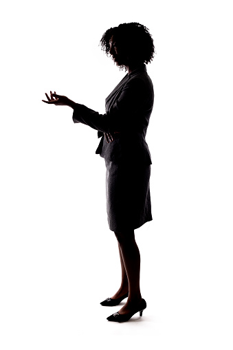 Silhouette of a Black Businesswoman gesturing like she is speaking or giving a speech like a teacher, presenter or a political candidate campaigning.