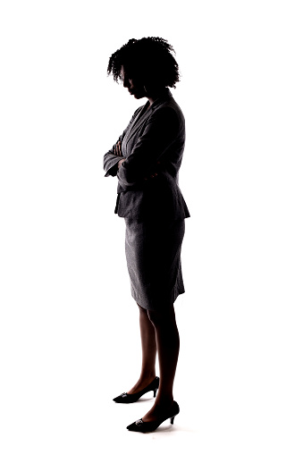 Silhouette of a Black Businesswoman posing sad by holding head low. She is isolated on a white background