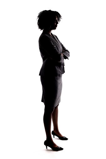 Silhouette of a black businesswoman or an anonymous female presidential candidate.  The person is backlit and isolated on a white background.