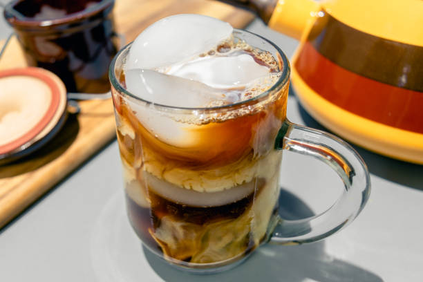milk swirling in a cold cup of iced coffee stock photo