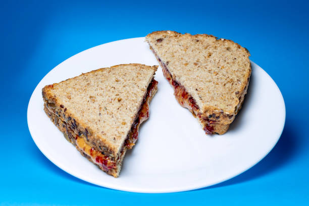 Peanut butter and jelly sandwich on white glass plate stock photo