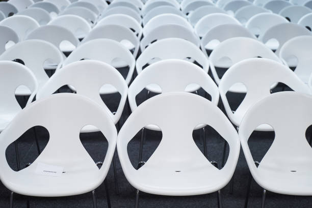 istock Empty auditorium hall with rows of white plastic seats. 1133262245
