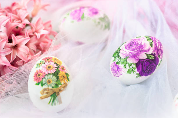 Beautiful Easter eggs decorated with paper napkins and flowers on white tulle background; decoupage technique Beautiful Easter eggs decorated with paper napkins and flowers on white tulle background; decoupage technique decoupage stock pictures, royalty-free photos & images