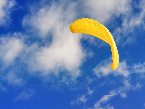 istock Flying yellow kite against blue cloudy sky 1133265035