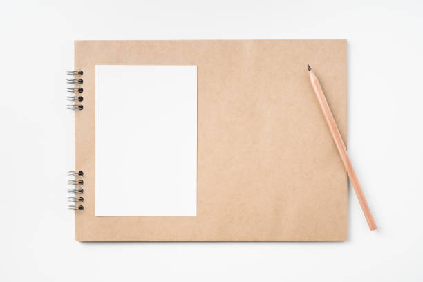istock kraft notebook, photo frame and pen on white 1133270988