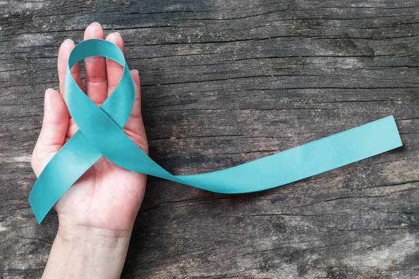 istock Turquoise/ Robin egg blue ribbon on human hand old aged background raising awareness on Bone tumor, Addiction recovery 1133275194