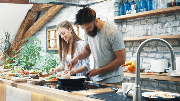 istock Young couple making dinner together at home 1133275239