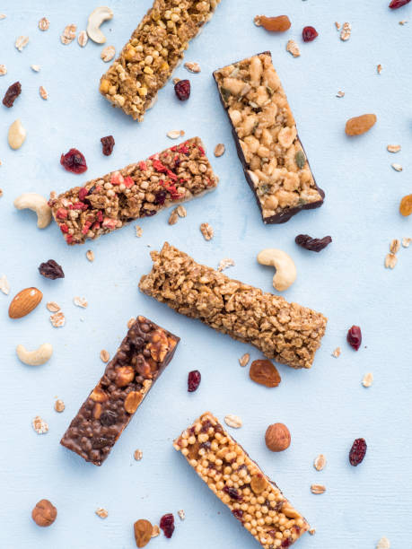 conjunto de diferentes barras de granola sobre fondo azul - protein bar cereal oat cranberry fotografías e imágenes de stock