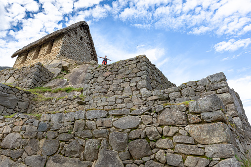 Cusco, Peru - Oct 16, 2018: A tourist is overlooking the scenery in Machu Picchu, Peru.