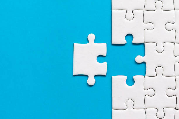 istock White jigsaw puzzle on blue background. Team business success partnership or teamwork 1133293115