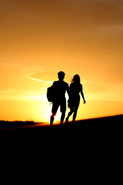 romantyczna przygoda para zachód słońca - sunrise beach couple hiking zdjęcia i obrazy z banku zdjęć