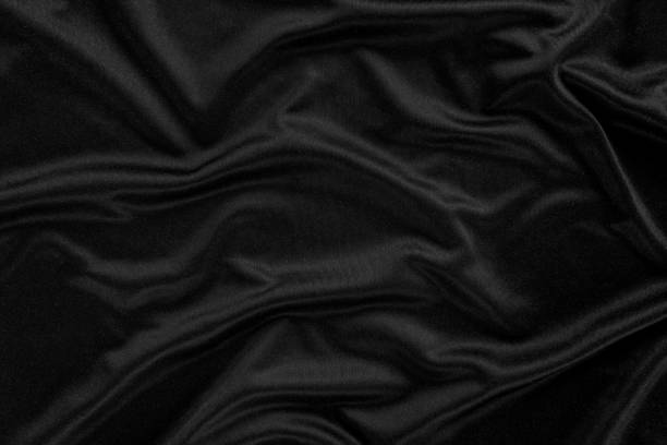 istock Abstract background. luxury cloth or liquid wave or wavy folds.Black satin fabric texture wallpaper. 1133307876