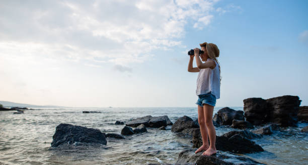 istock Girl use binoculars at the beach 1133309082