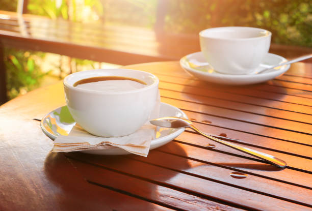 black coffee in cup white on table wood floor background in morning