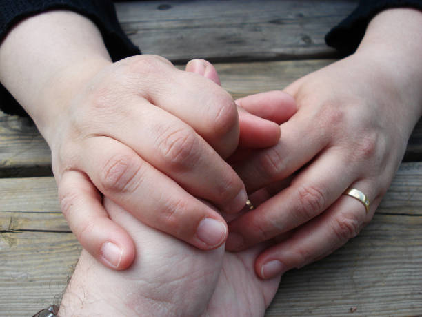istock Couple holding hands at a wooden table 1133317905