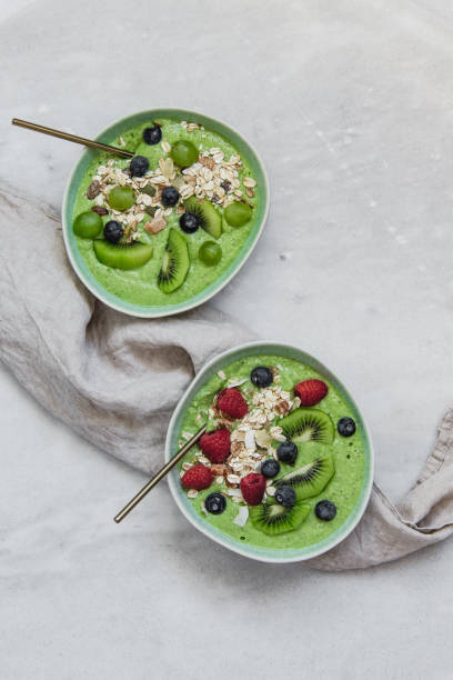 istock Smoothie breakfast bowls with berries, seeds, oats and nuts on white background with copy space 1133317909