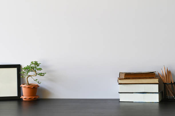 istock Workspace books, pencil, photo frame and bonsai on office desk. 1133318971