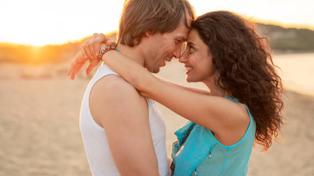 istock Couple in love embracing on the beach at sunset 1133320236