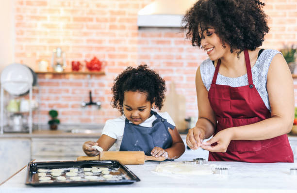 istock Mother and child rolling out dough together 1133323082