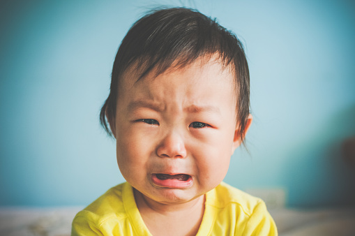 A Asian baby girl crying at home