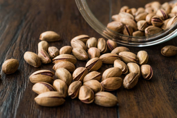 istock Pistachio Nuts with Shell on Dark Wooden Surface. 1133326388