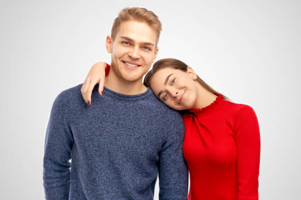 istock Smiling young nice lady with gentle look keeps hand on shoulder of happy bearded guy, spend free time together. Models isolated on white background in studio 1133326699