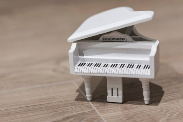 istock White tiny wooden piano on a wooden surface 1133327296