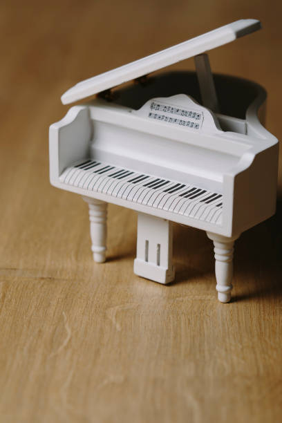 istock White tiny wooden piano on a wooden surface 1133327418
