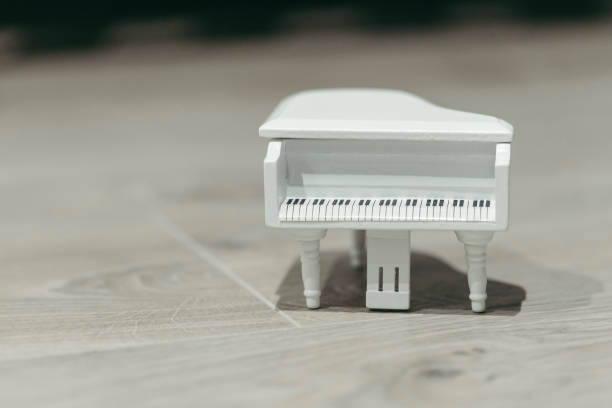istock White tiny wooden piano on a wooden surface 1133327448
