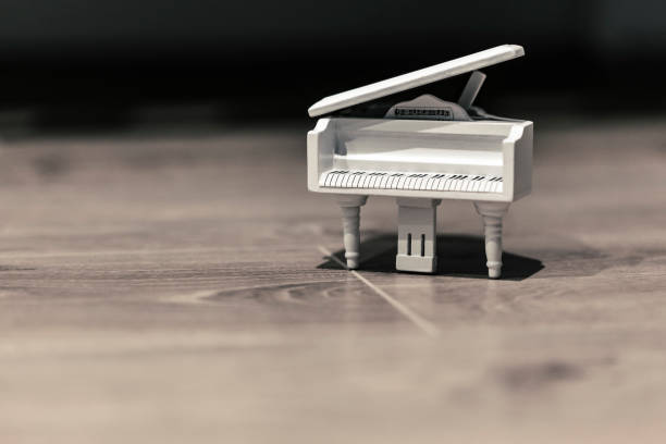 istock White tiny wooden piano on a wooden surface 1133327460