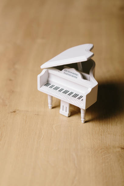 istock White tiny wooden piano on a wooden surface 1133327473