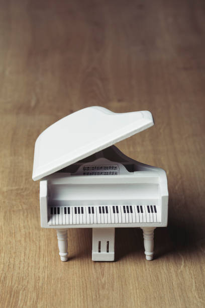 istock White tiny wooden piano on a wooden surface 1133327499