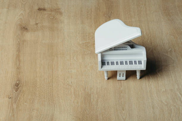 istock White tiny wooden piano on a wooden surface 1133327524