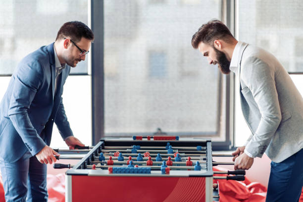 istock Smiling business colleagues playing table football 1133328736