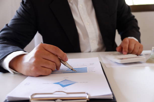 istock Businessman working in office using calculator with document on desk. 1133329297