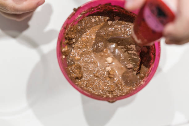istock Baby breakfast Cocoa with milk prepared on a pink plastic glass on a white background 1133332017