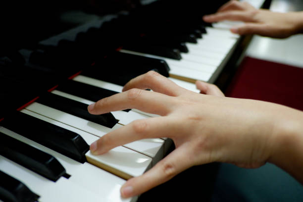 istock close-up female hand playing grand piano. 1133332987
