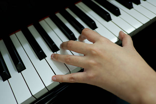 istock close-up female hand playing grand piano. 1133332988