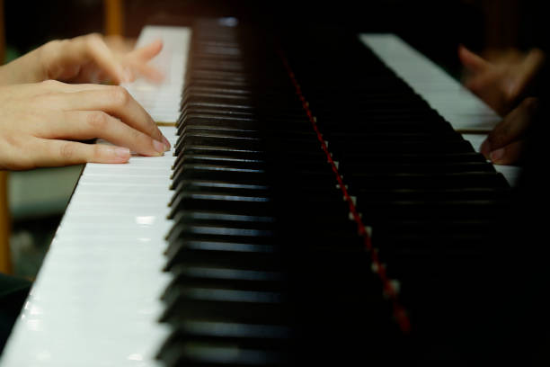 istock close-up female hand playing grand piano. 1133332991
