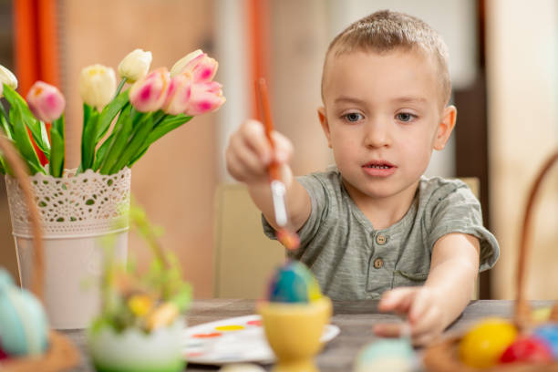 istock Cute little boy painting Easter eggs 1133333257