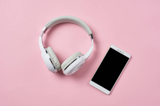 istock White wireless headphones and smartphone on a pastel pink background 1133338097