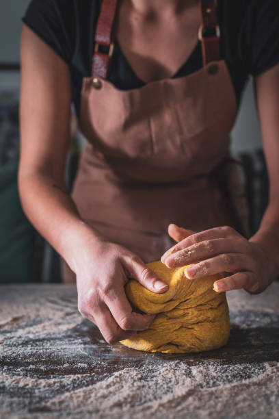 avental desgastando do cozinheiro chefe da mulher que amassar a massa à mão na padaria - bread kneading making human hand - fotografias e filmes do acervo