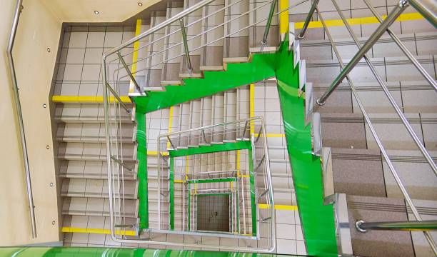 istock Perspective spiral square staircase in green colors inside modern building 1133342274