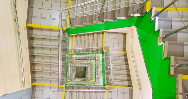 istock Perspective spiral square staircase in green colors inside modern building 1133342301