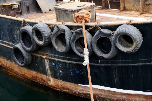 Tyres rubber on wooden boat at port harbour uk