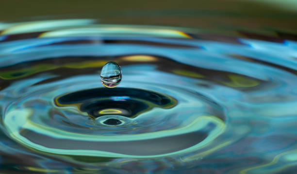 water drop impact water drop falling and impacting on a body of water close up moving down photos stock pictures, royalty-free photos & images