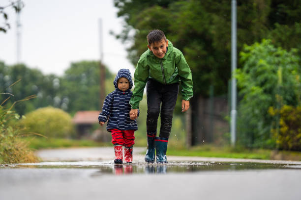 istock siblings walking together outdoors on rainy day 1133352404