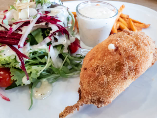 istock Fish fritters stuffed with cheese served with salad and a sauce 1133352582