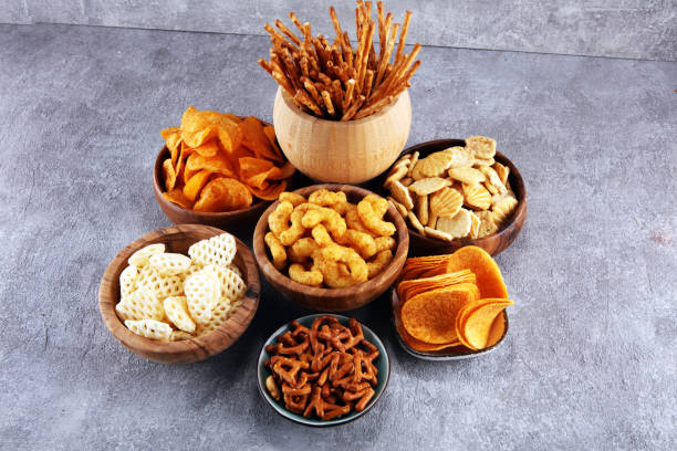 istock Salty snacks. Pretzels, chips, crackers in wooden bowls. 1133352859